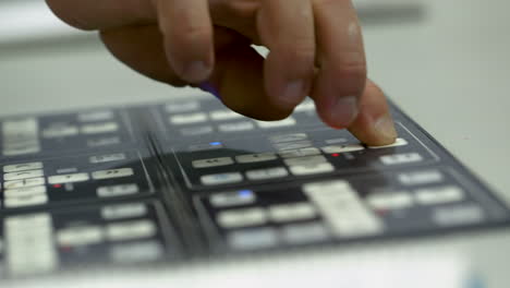 closeup of caucasian man's hand operating a machine panel