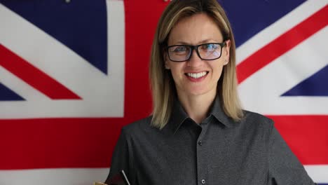 smiling woman with glasses in front of the british flag