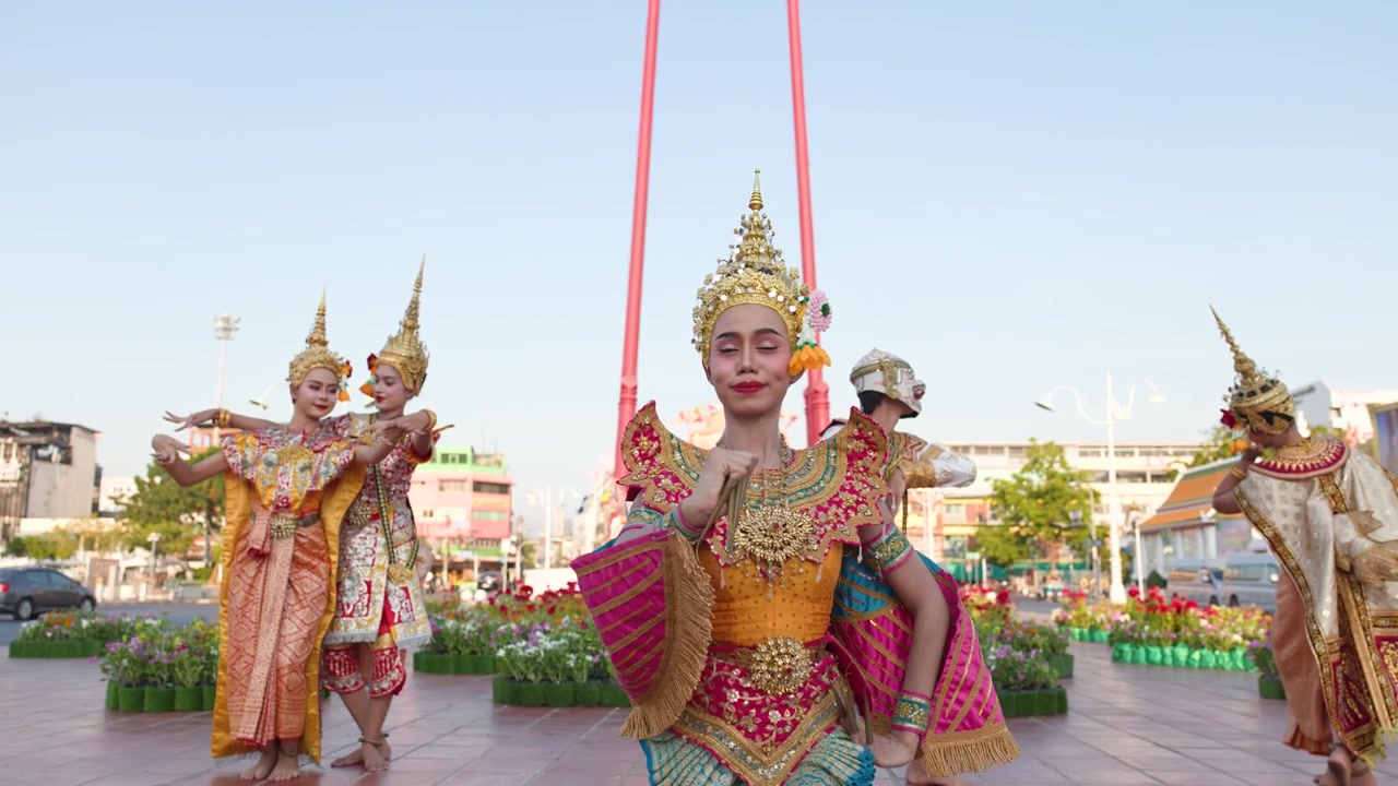 Ballerini thailandesi in costumi sontuosi eseguono movimenti classici Khon all'aperto presso un tempio storico