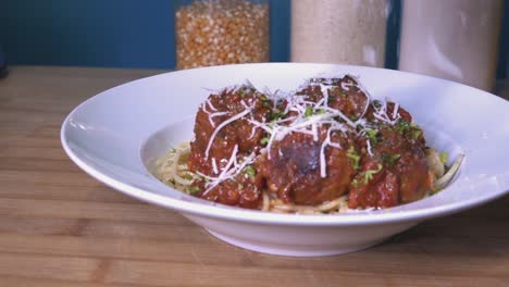 Grating-Fresh-Parmesan-on-Homemade-Meatballs-on-Kitchen-Counter