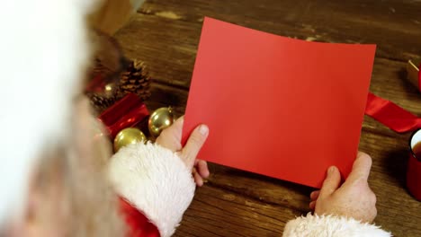 santa claus holding a blank christmas card