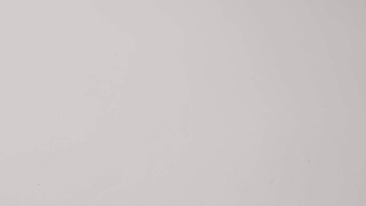 tomando a mano un huevo marrón colocado en una superficie blanca, toma de estudio de primer plano