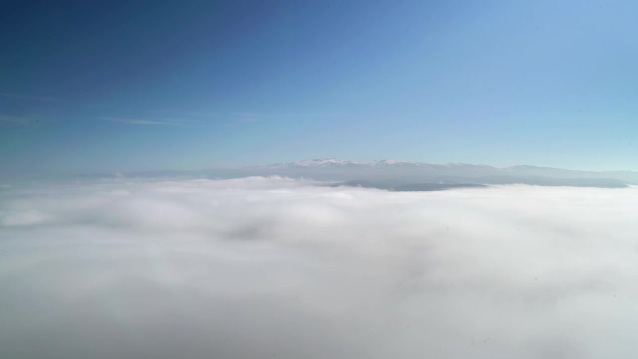 Aerial View of Mountain Peaks Above a Thick Layer of Clouds