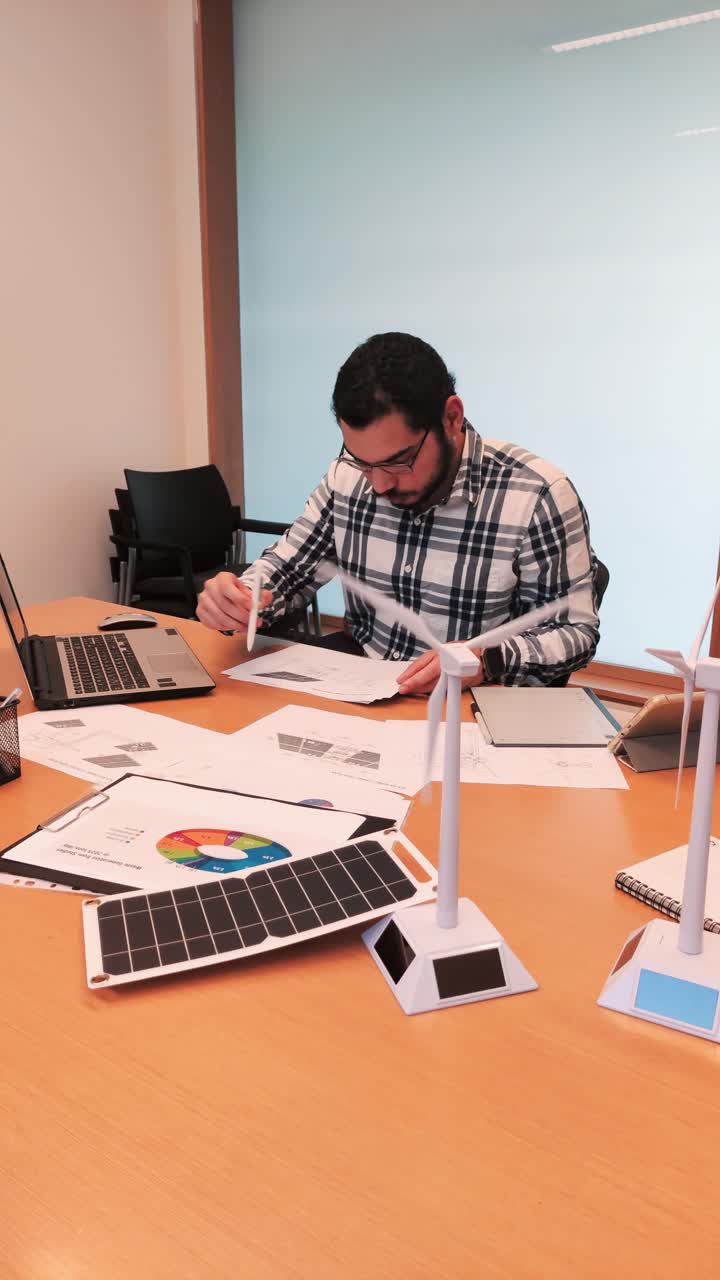 Young Engineer Studying Technical Documents for a Green Energy Project