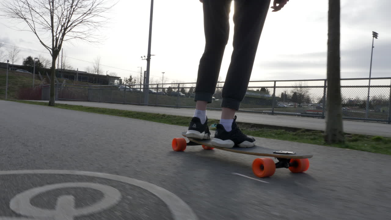tiro de pista de ángulo bajo de skater montando patineta al aire libre en carretera de bicicleta de asfalto