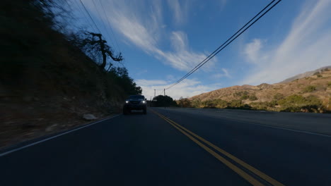 cinematic fpv shot of a tactical suv driving along a country road