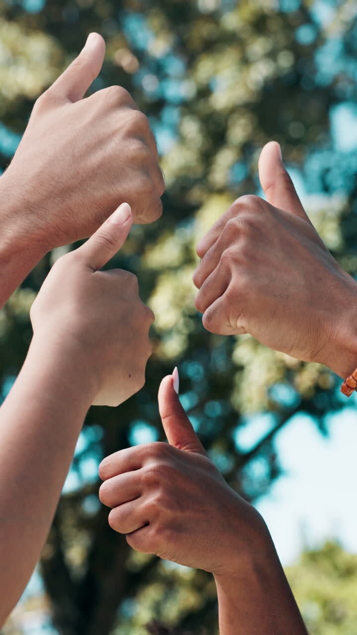 Diverse mani che fanno il gesto del pollice in su su uno sfondo verde sfocato
