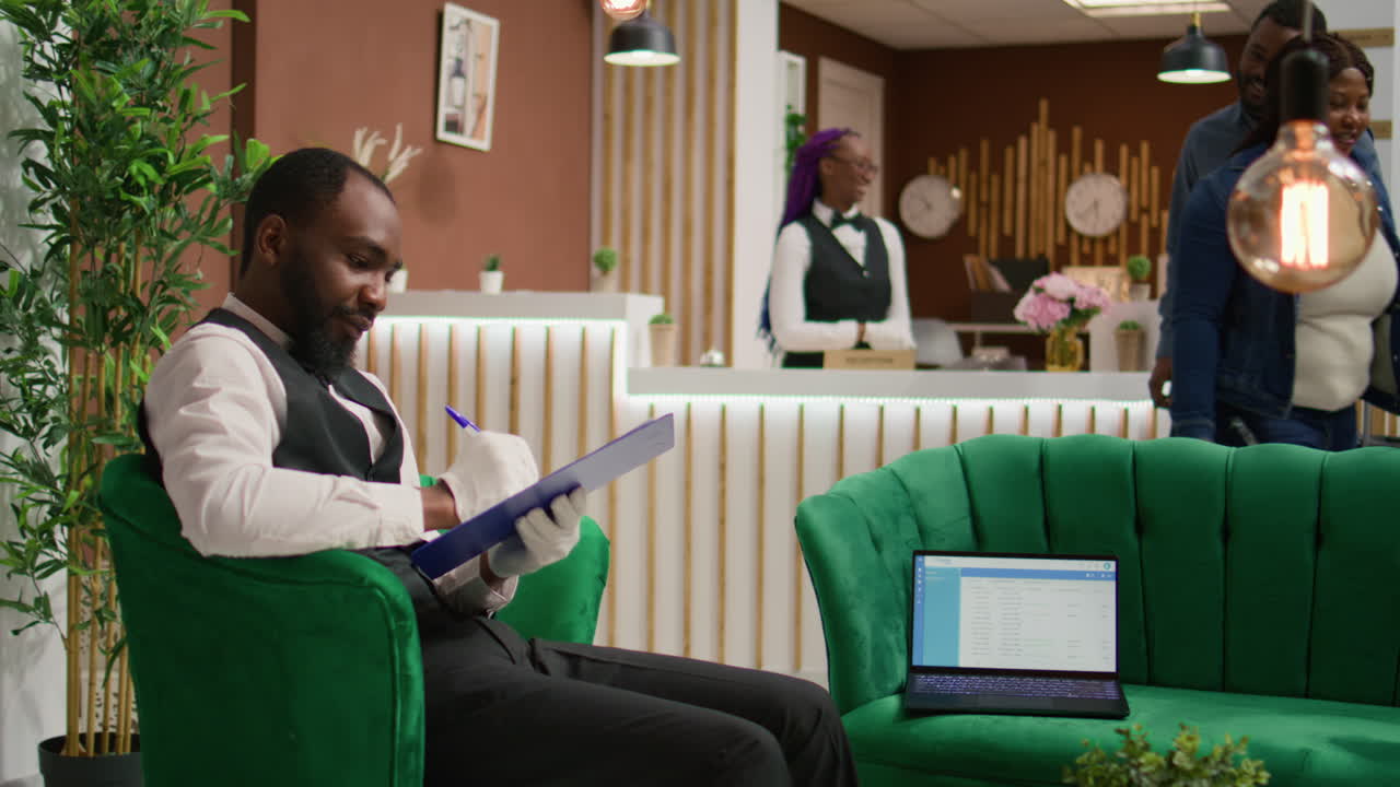 el camarero del hotel lee la información de los huéspedes.