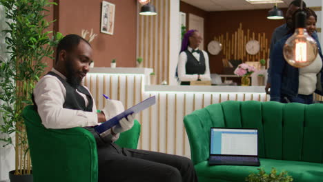 hotel bellhop reads guests information