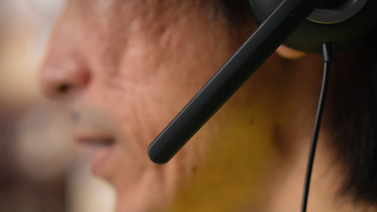 Close up of male staff answers help line calls in a logistics depot