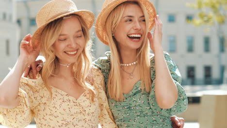 two happy women wearing straw hats