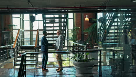 businessmen shaking hands in modern office