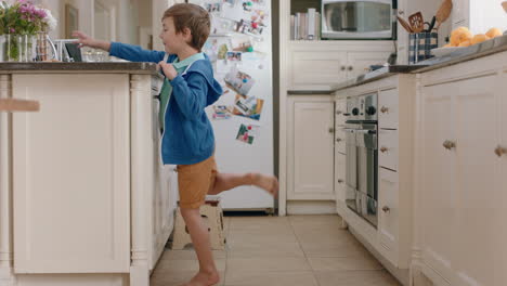 happy little boy taking cookie sneaky child stealing biscuit in kitchen at home