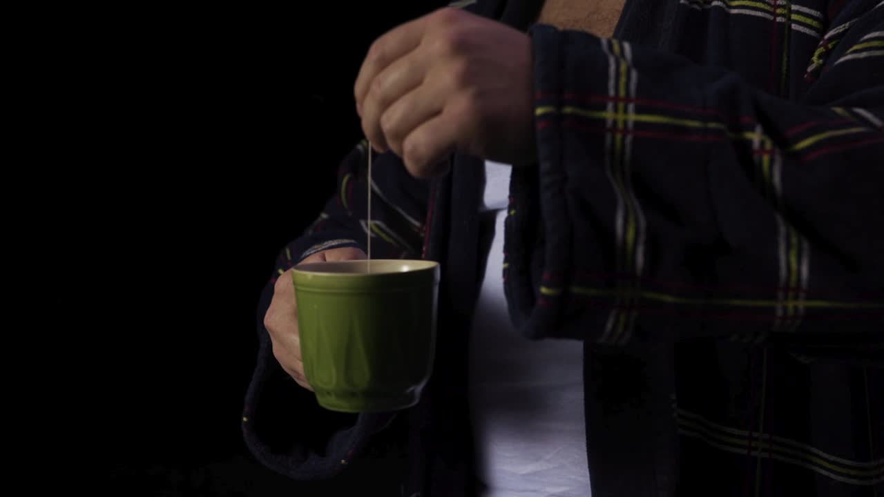 hombre con túnica a cuadros preparando té