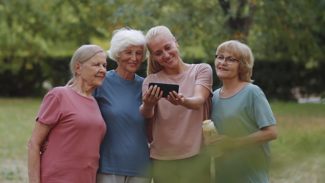 entrenadora de fitness tomando selfies con mujeres mayores en el parque
