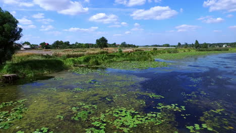 Pueblo-De-Paisaje-Aéreo-En-La-Orilla-Del-Río.-Pescador-Pescando-En-Un-Barco-De-Pesca