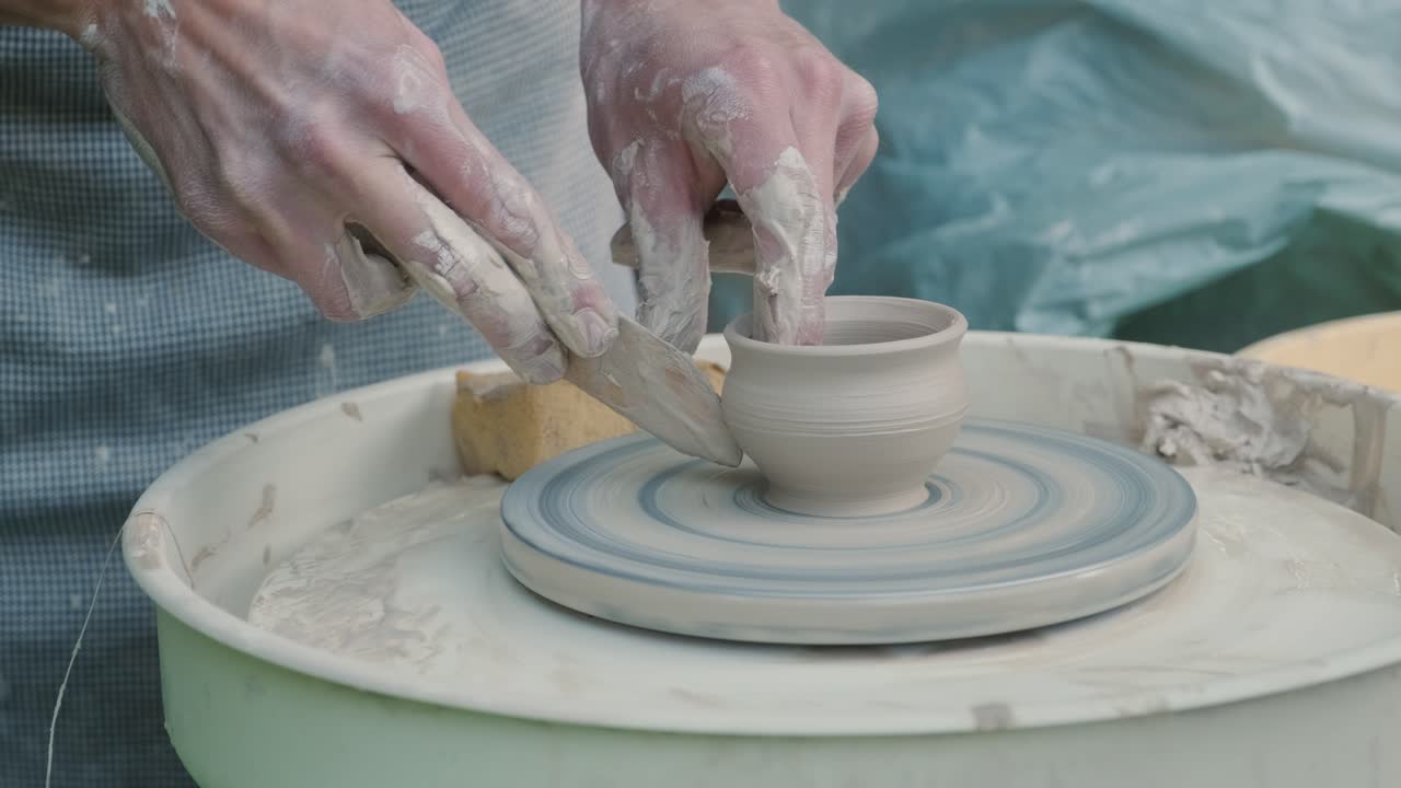 도자기의 바에서 점토로 작업하는 손의 가까운 모습. 공예가 도자기 바에 점토 제품을 형성합니다.
