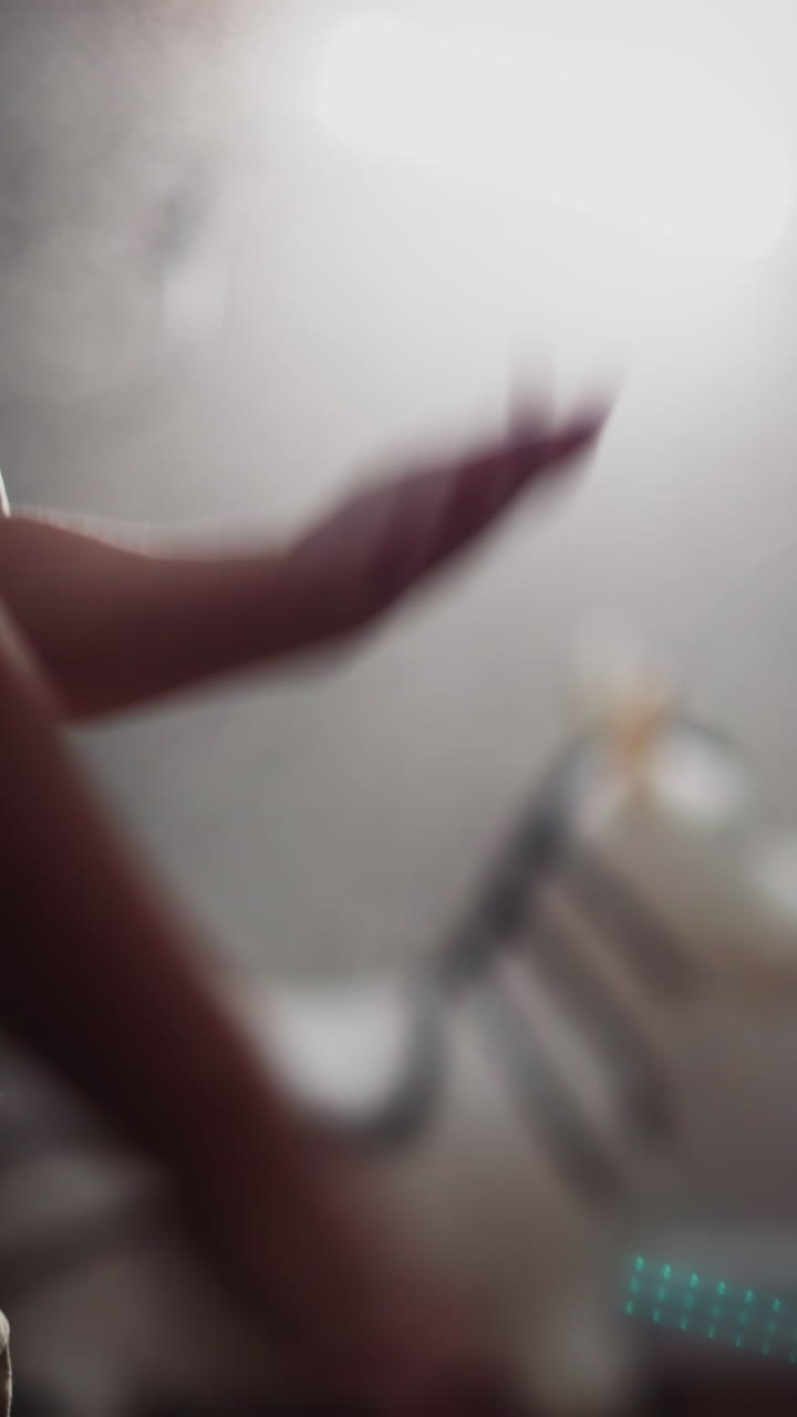 Sportive kid claps hands to shake off talcum powder after punching bag against bright lamp spreading light. Little boy stops boxing in gym closeup slow motion