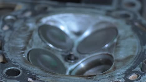 focused on a mechanic's skilled hands as they carefully clean and maintain a valve on an engine. the precision highlights the importance of automotive care and attention to detail.