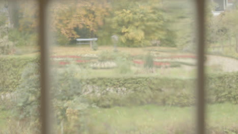 pov focus rack from old window to beautiful green castle garden