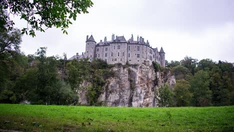 Schloss-Auf-Einer-Klippe-Im-Zeitraffer-Mit-Wolken,-Die-über-Die-Grasbewachsenen-Pinienfelder-In-Dinant,-Belgien,-Ziehen