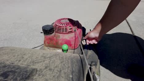 checking the oil and filling the gas on a dirty lawn mower. from the mowers view, looking at the engine.