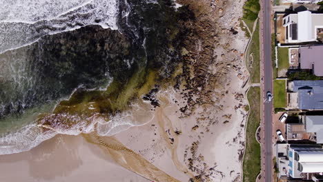 Tanninreiches-Wasser-Aus-Der-Lagune-Fließt-über-Den-Strand-Und-Gelangt-In-Den-Ozean,-Onrus