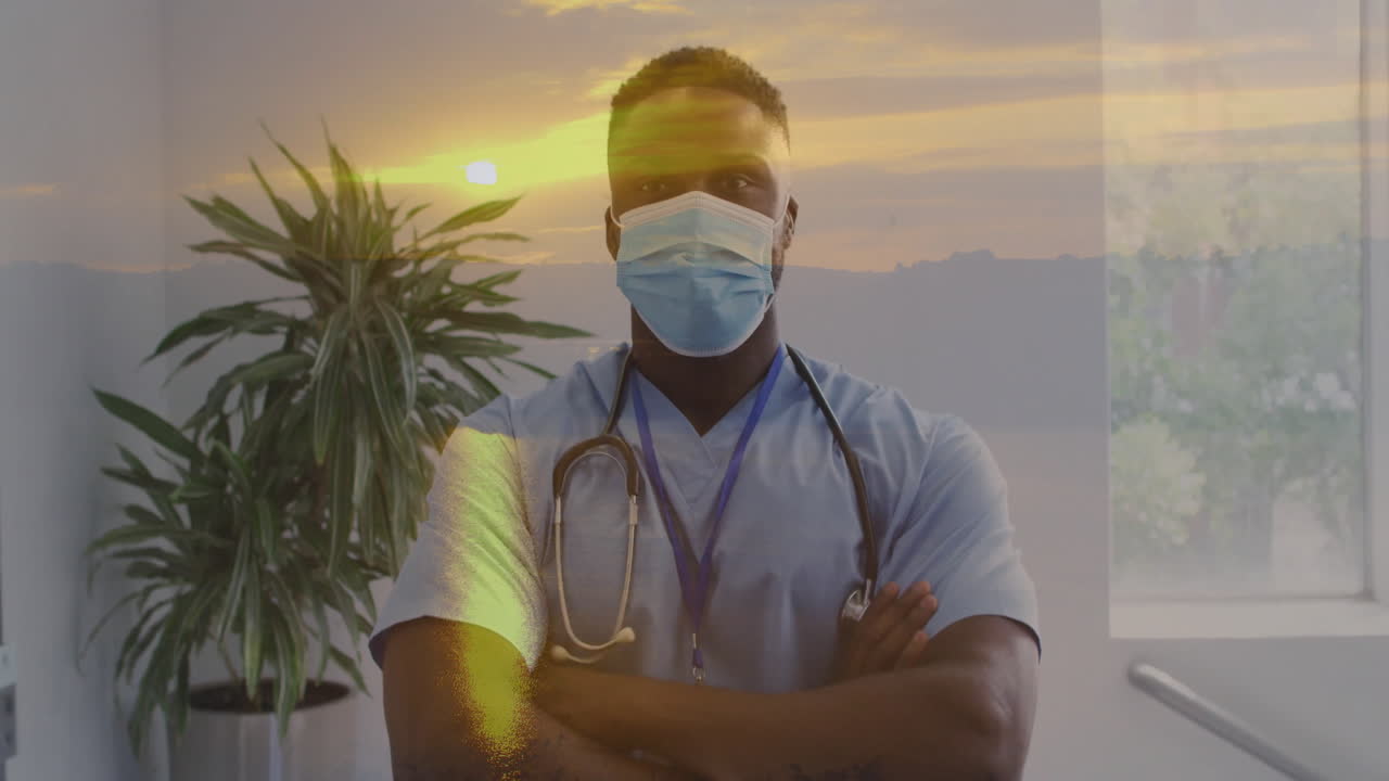 Professionnel de la santé portant un masque et une blouse chirurgicale, avec une animation de coucher de soleil en arrière-plan.