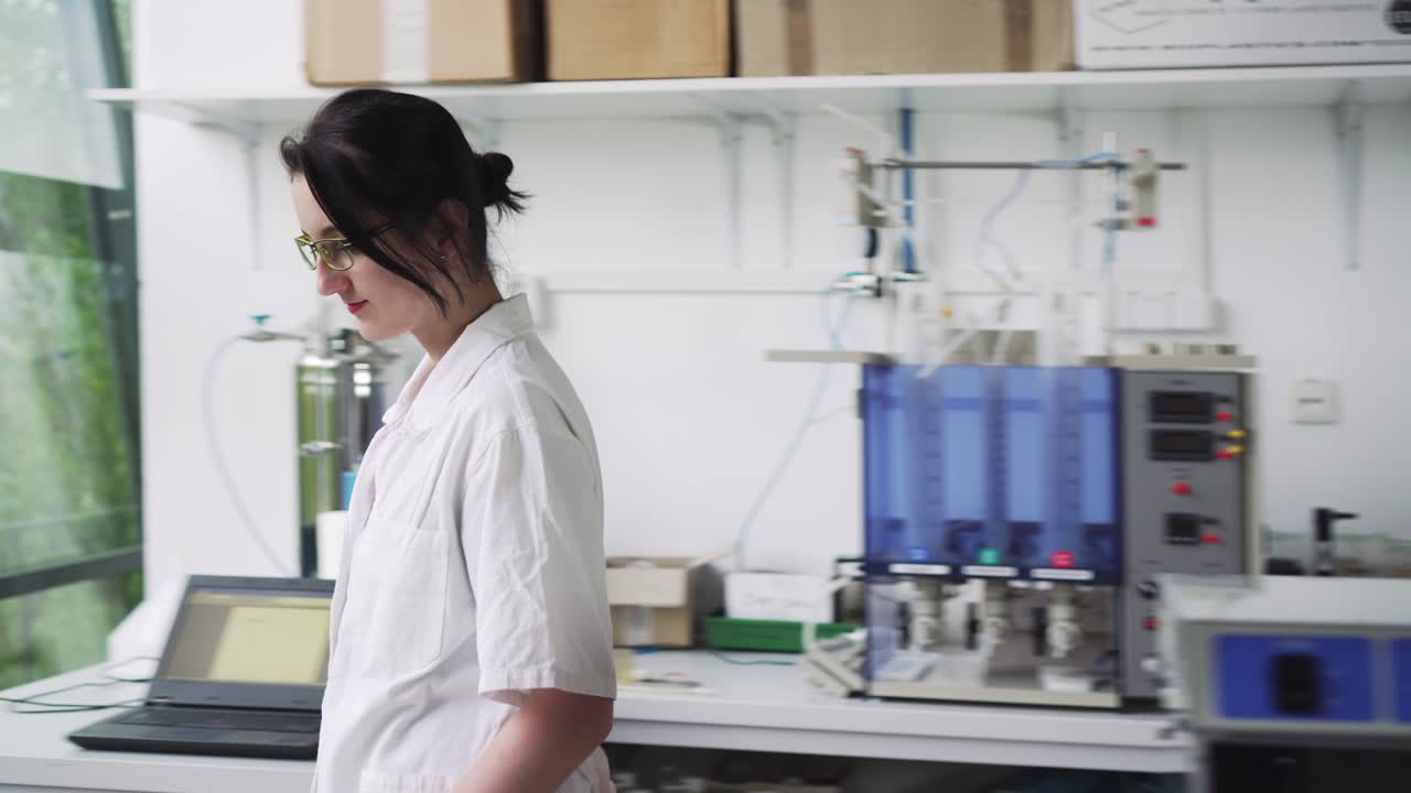 Laboratory worker holding blood sample in test tube near window, middle shot, front view