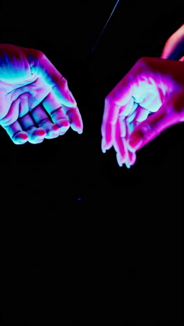 neon lit hands in abstract darkness