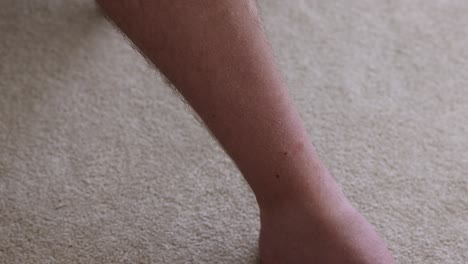 close-up shot of a man removing multiple ticks from a mans shin after being outside