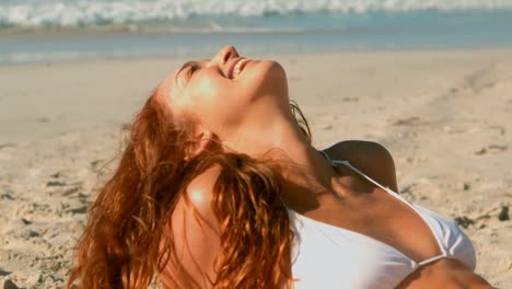 hermosa mujer caucásica en bikini relajándose en la playa al sol 4k