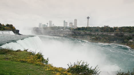 Schwenk:-Der-Mächtige-Wasserstrahl-Der-Niagarafälle,-In-Der-Ferne-Sieht-Man-Die-Kanadische-Küste