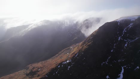 Drone-shot-flying-forward-with-mist-rolling-off-a-mountain,-Helvellyn,-Lake-District,-Cumbria,-UK