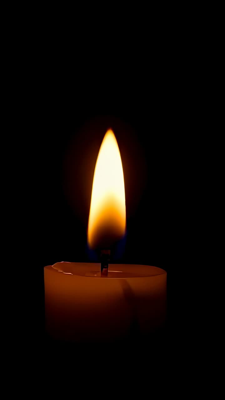 Video verticale: fiamma che si muove sulla sommità di una candela a colonna che reagisce a spifferi e cera che si scioglie in una stanza buia