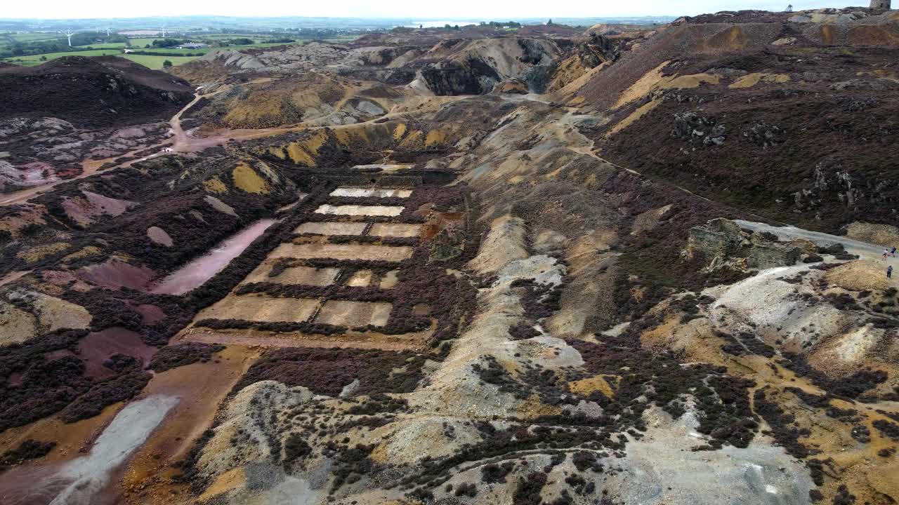 Parys mountain abandoned historic copper mine red stone mining industry landscape aerial view descending birdseye