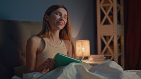 writer noting ideas bedroom sitting cozy bed close up. smiling woman writing