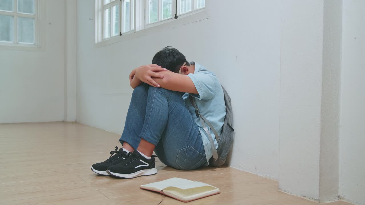 Young Asian Boy Sitting Alone With Sad Feeling At School. Bullying, Discrimination And Racism Concept
