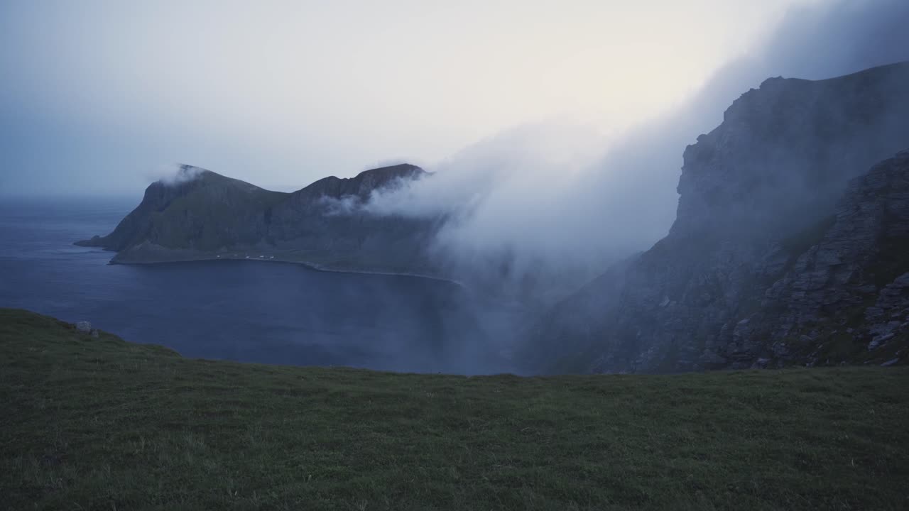 nubes rodando sobre la cordillera en værøy, noruega
