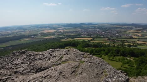 Right-to-Left-pan-from-the-top-of-franconian-Staffelberg,-flag-in-the-wind-and-foresight-into-franconia
