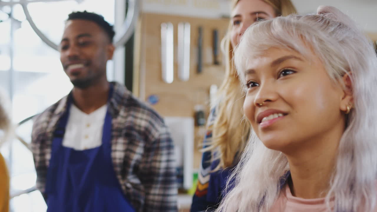 equipo multicultural de aprendices en el taller aprenden a ensamblar un marco de bicicleta construido a mano juntos