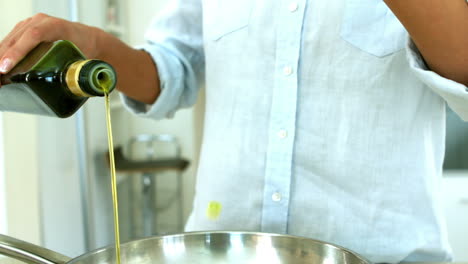 Woman-pouring-oil-onto-the-frying-pan