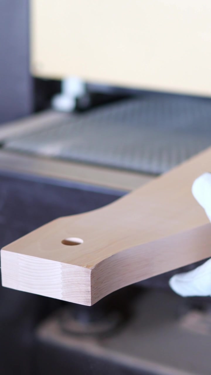 Gloved Hand Picking Up a Finished Wooden Board