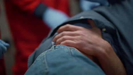 Close-up-view-of-paramedic-doctor-hands-providing-first-aid-to-man