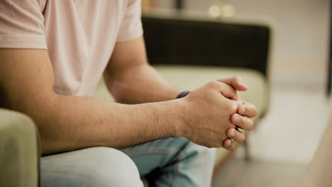 hombre sentado en el sofá, manos juntas, en una conversación relajada