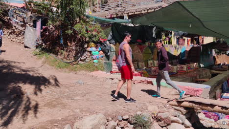man walking through colorful market in ourika valley, morocco under shaded canopy
