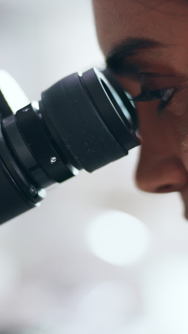 Close-up of a person using a microscope
