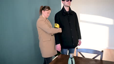 woman putting armband to her blind boyfriend and leaving home together