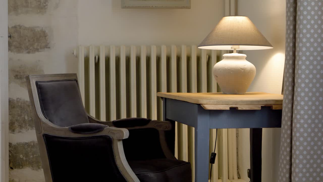Leather chair and small table with lamp in rustic Mediterranean villa, Dolly right reveal shot