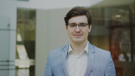 man in a light blue blazer smiling